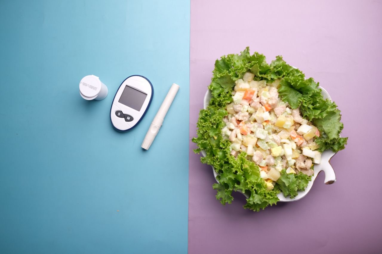 Top view of diabetes equipment and fresh salad representing healthy living.